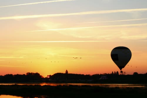 Hot air balloon at sunrise over Loire River near Chateau Haute Roche, Oudon, France