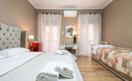 Camera Platinum dello Yaki Domo B&B a Cagliari con due letti, biancheria bianca, arredamento moderno e luminose finestre con tende