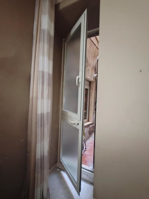 Accesso alla camera Silver di Yaki Domo B&B a Cagliari, con vista sulla corte interna e porta in vetro con telaio bianco