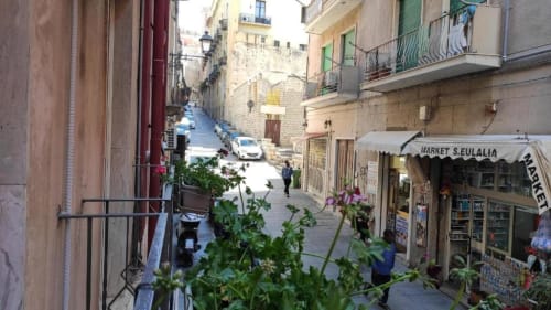 Affascinante vicolo di Cagliari con edifici storici, negozio Market S.Eulalia e balconate sul selciato