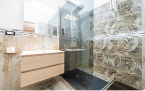 Bagno moderno nella camera Yaki Domo Silver a Cagliari con doccia a fondo stanza, lavabo vanity e pareti rivestite in piastrelle decorate