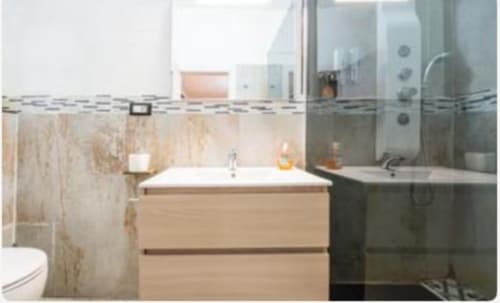 Bagno moderno della camera Yaki Domo Silver a Cagliari con mobile in legno, doccia walk-in e pareti piastrellate