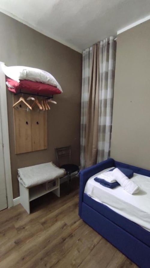 Camera Silver dello Yaki Domo B&B a Cagliari con letto blu, attaccapanni in legno e vista sulla corte interna