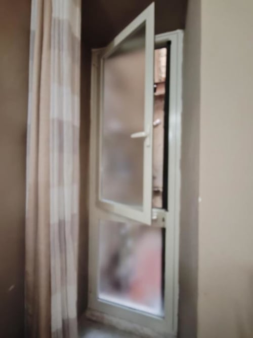 Porta con cornice bianca e pannello in vetro che si apre sul cortile interno della Silver Room di Yaki Domo a Cagliari