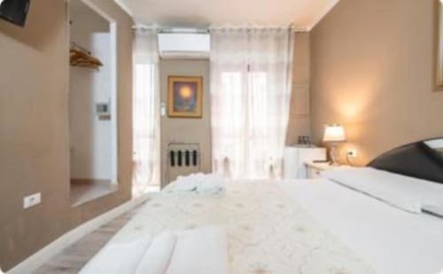 Luminosa camera Gold al Yaki Domo B&B di Cagliari con letto bianco, balcone e servizi moderni