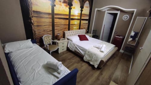 Camera argento presso il Yaki Domo B&B di Cagliari con due letti, arte murale sul tramonto e arredi moderni