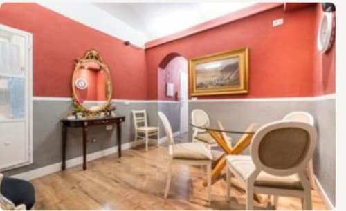 Stanza Gold di Yaki Domo B&B a Cagliari con pareti rosse e grigie, mobili in legno e elegante area lounge