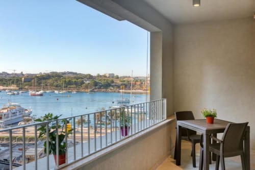Balcone con vista sul mare a Marea Sliema, Malta: tavolo da pranzo con affaccio sulla baia blu e barche ormeggiate