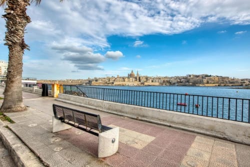 Passeggiata sul lungomare di Marea Sliema con panchina con vista sul porto di Sliema e l'architettura storica