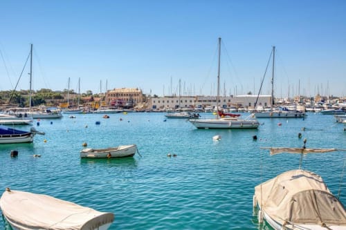 Porto turchese con barche ormeggiate e barche a vela a Marea Sliema, vista sul Mediterraneo a Sliema, Malta