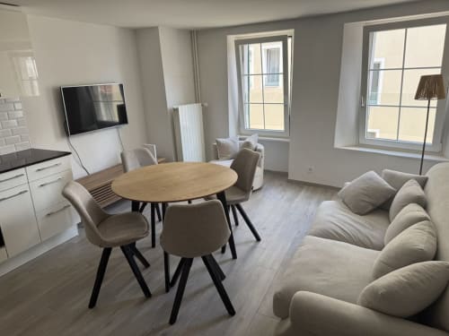 Appartement Zogbi Hospitality moderne à Aubonne avec séjour ouvert, table à manger, coin salon confortable et kitchenette