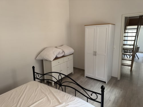 Chambre lumineuse à Zogbi Hospitality à Aubonne avec lits jumeaux, armoire et literie crème