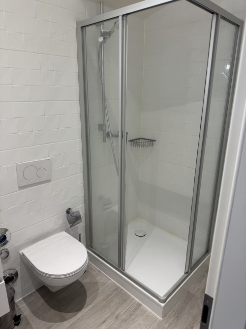 Salle de bain moderne à Zogbi Hospitality à Aubonne avec douche vitrée et toilettes murales