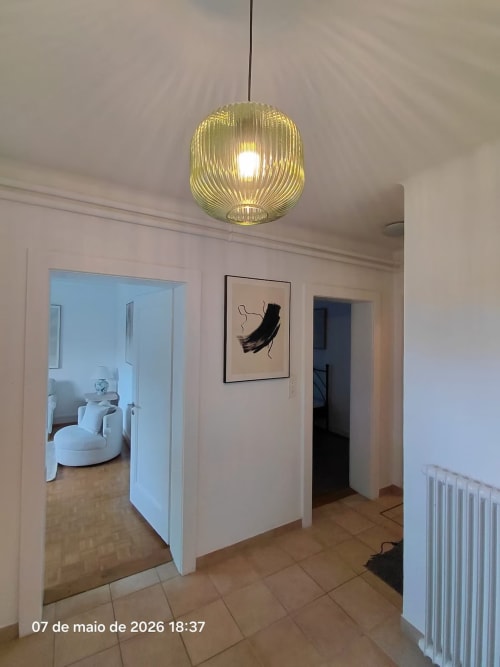 Couloir moderne de l'appartement Zogbi Hospitality à Lausanne avec éclairage suspendu et art contemporain