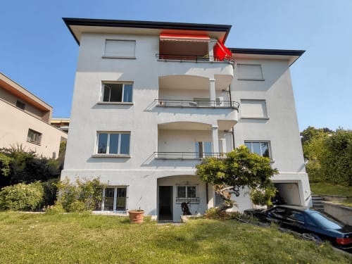 Immeuble blanc moderne à Pully, Lausanne avec balcons, jardin et parking
