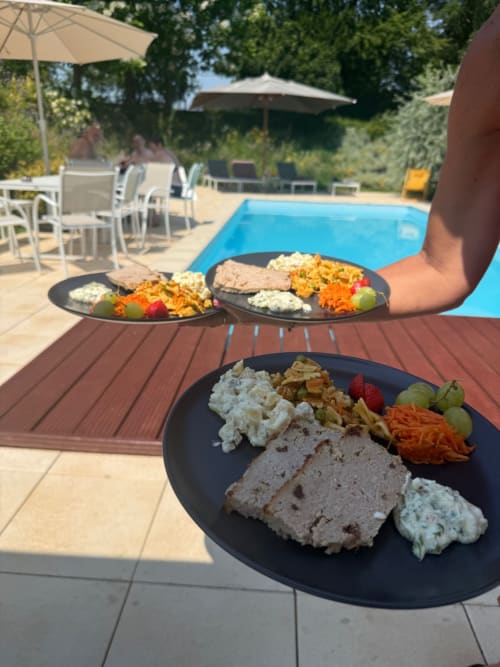 Drie borden maaltijden bij het zwembad van Villa Bianca in Mortroux Dalhem met pâté, groenten en bijgerechten