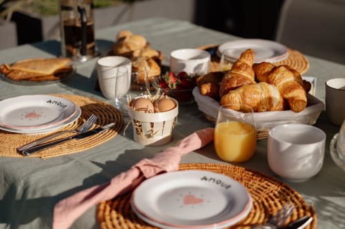 Table de petit-déjeuner élégante au Manoir de la Nogrie avec croissants, jus et couverts à Val d'Izé