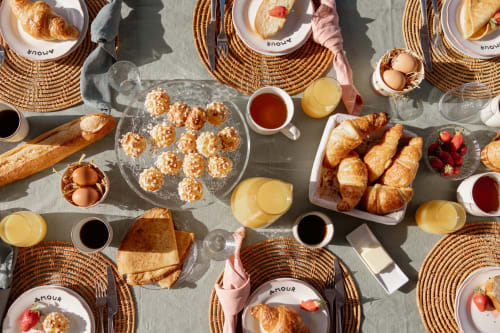 Petit-déjeuner français au Manoir de la Nogrie avec croissants, pâtisseries, fruits rouges frais, jus et café
