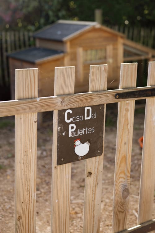 Enseigne Casa Del Poulettes sur clôture en bois au poulailler du Manoir de la Nogrie à Val d'Izé, France