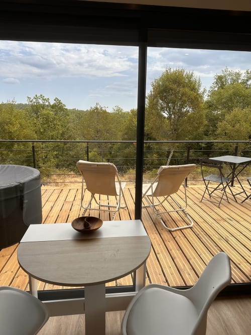 Balcon moderne du gîte l'Harmonie du Causse avec vue sur les montagnes, sièges confortables et terrasse en bois
