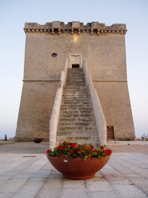 Torre storica in pietra a Torre Lapillo con fiori rossi, villa Casa Alba a My Home Apulia, Italia