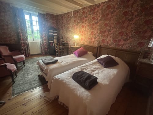 Deux lits jumeaux dans La chambre Fleurie de la Cour Du Liège, un manoir chambres d'hôtes français à Baugé-en-Anjou au décor floral d'époque