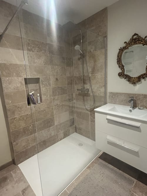 Salle de bain moderne avec douche à l'italienne, vasque blanche et miroir décoratif au gîte Cour Du Liège à Baugé-en-Anjou