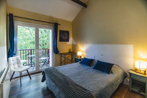 Chambre double avec vue sur le jardin à l'Hôtel De La Bonnheure à Bracieux, accents bleus et accès au balcon