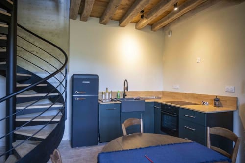 Cuisine moderne avec placards bleu marine et plan de travail en bois au cottage Le Fruitier de la Cour Du Liège, Baugé-en-Anjou