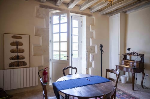 Salle à manger du cottage Le Fruitier à la Cour Du Liège avec poutres apparentes, portes-fenêtres et vue sur le jardin à Baugé-en-Anjou