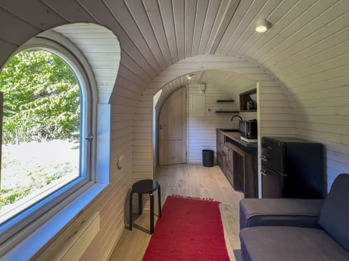 Intérieur du gîte Cour Du Liège avec cuisine, coin séjour et vue sur le jardin depuis la fenêtre cintrée