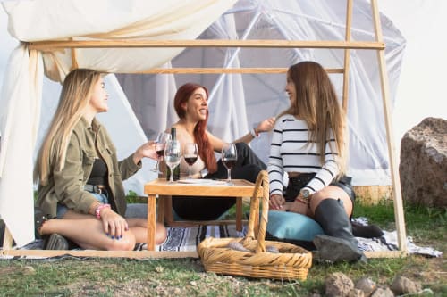 Tres mujeres disfrutando vino en una lujosa tienda domo en Mars Glam Camp, Aguascalientes, con vistas a las montañas