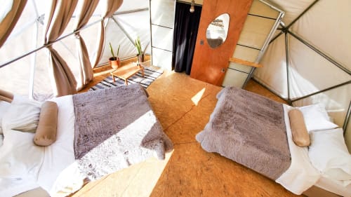 Interior moderno de domo glamping en Mars Glam Camp con camas gemelas, piso de madera y techo transparente con vistas