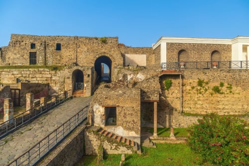 Antica fortezza in pietra con portali ad arco presso Anima Est B&B in Italia sotto un cielo azzurro limpido