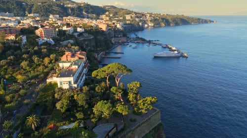 Anima Est B&B arroccato su scogliera con vista sul Mar Mediterraneo sulla costa italiana, tra barche e lussureggiante vegetazione
