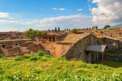 Antichi resti romani presso l'Anima Est B&B in Italia con strutture in pietra, terreni verdi e cielo nuvoloso
