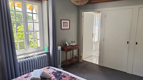 Bright bedroom at Le Moulin de Bacchus B&B in Chancay with river views, featuring a double bed, wooden desk, large wardrobe,