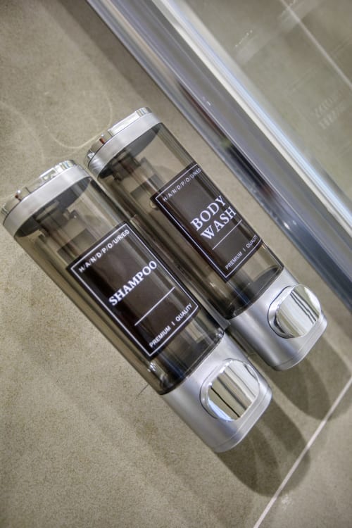 Prodotti per l'igiene personale nella camera dell'hotel Marea Sliema, con flaconi premium di shampoo e bagnoschiuma dotati di erogatori bianchi