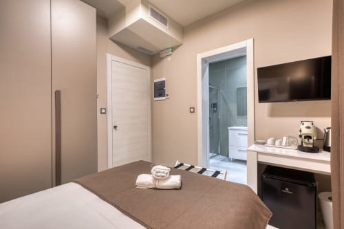 Camera moderna dell'hotel Marea Sliema a Malta con letto, TV, bagno privato, macchina da caffè e arredamento contemporaneo