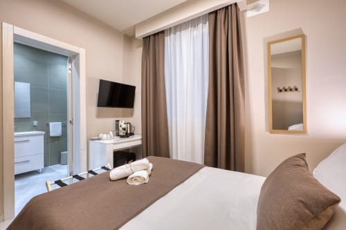 Camera moderna a Marea Sliema con letto, TV a schermo piatto, bagno privato e tende dal pavimento al soffitto