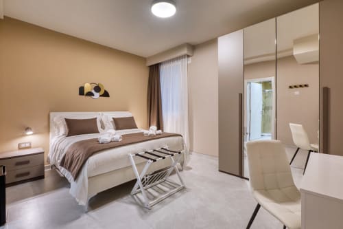 Camera moderna dell'hotel Marea Sliema con letto queen, armadio con specchio, bagno ensuite e arredi contemporanei