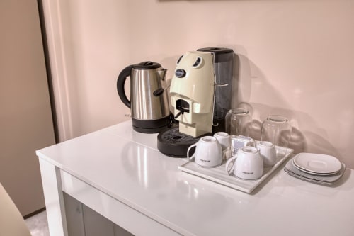 Angolo caffè con bollitore, macchina Nespresso, tazze e bicchieri all'hotel Marea di Sliema a Malta