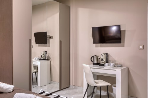 Camera moderna dell'hotel Marea Sliema con TV a parete, scrivania con sedia, macchinetta del caffè e bagno ensuite