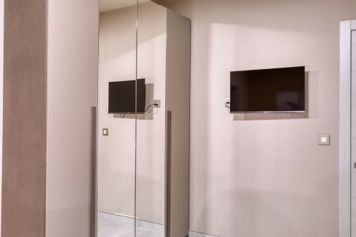 Bagno moderno con doccia in vetro e TV a schermo piatto presso l'hotel Marea Sliema, Malta