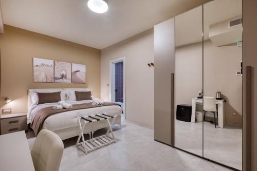 Camera da letto moderna a Marea Sliema con letto matrimoniale, armadio specchiato e arredamento neutro raffinato