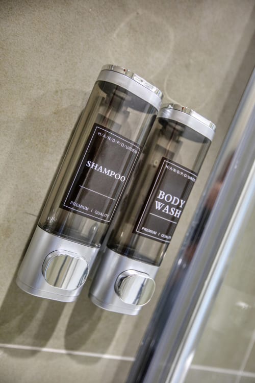 Dispenser di shampoo e bagnoschiuma premium nel bagno dell'appartamento Marea a Sliema, Malta