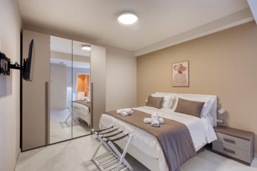 Camera elegante a Marea Sliema, appartamento Libeccio 5 a Sliema con letto matrimoniale, armadio specchiato e arredamento moderno