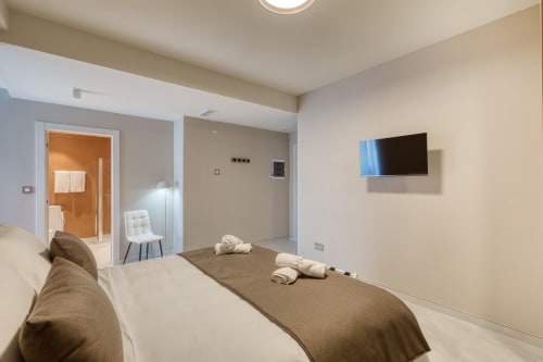 Camera moderna a Marea Sliema BnB con TV a parete, bagno privato e arredamento minimalista
