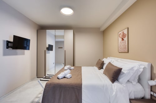 Camera da letto moderna a Marea Sliema con letto, TV, bagno privato e arredamento contemporaneo a Sliema, Malta