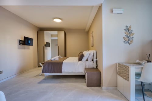 Camera moderna nell'appartamento Marea a Sliema, MT, con letto, armadio, TV e arredamento contemporaneo